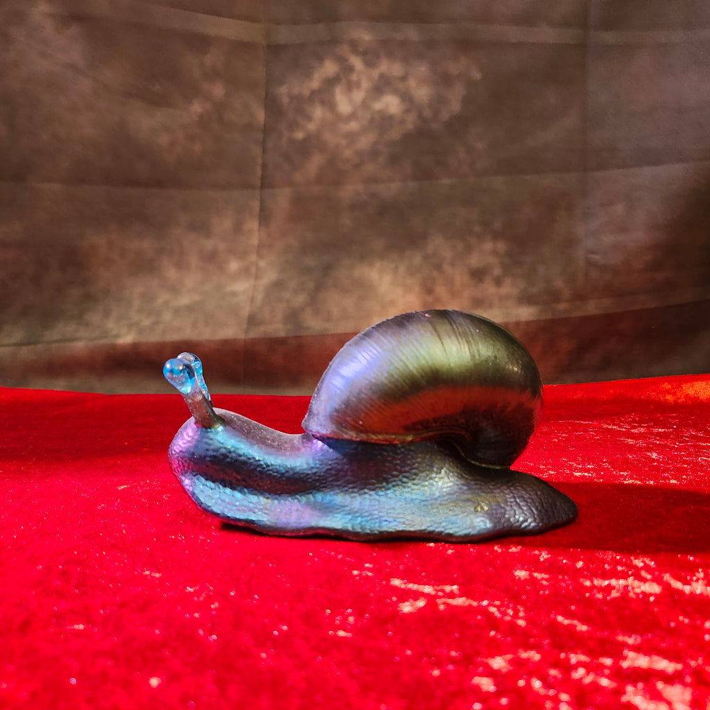 Solid hand-poured 3D resin fantasy snail sculpture featuring an iridescent metallic green shell, deep blue body, and translucent turquoise gemstone antennae.