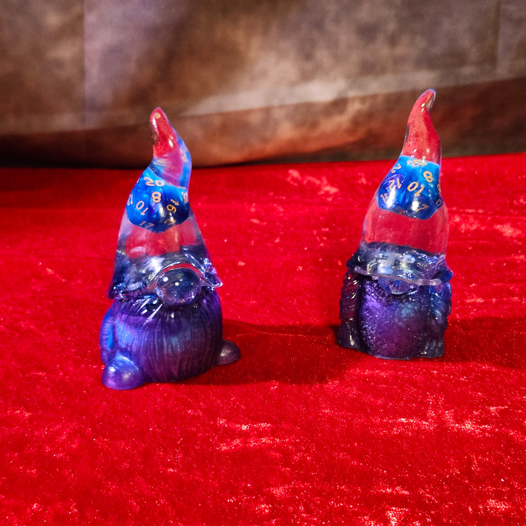 A matching two-piece set of handcrafted 3D resin fantasy gnomes featuring shimmering sapphire blue bodies and crystal-clear pointed hats with real blue D20 dice inside.