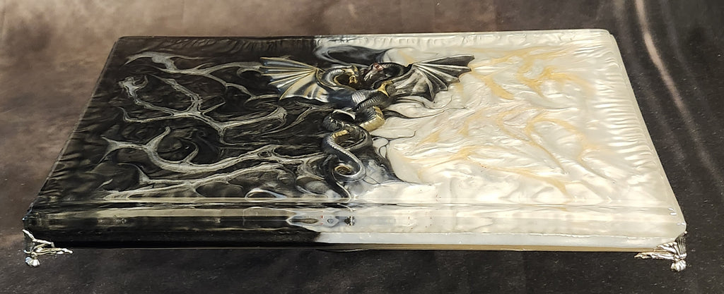 Handcrafted 3D dragon resin display riser tray featuring a split yin and yang midnight black and pearlescent gold fluid art design with ornate silver legs.